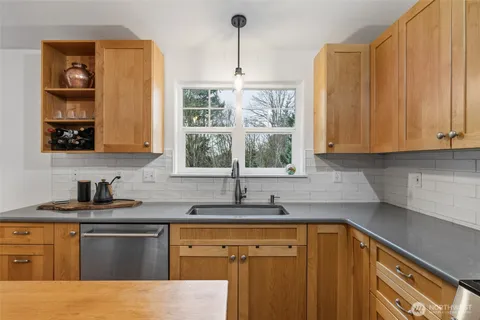 a kitchen with stainless steel appliances granite countertop a sink stove and cabinets