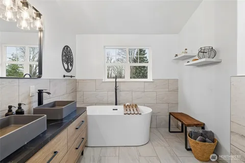 a bathroom with a tub a sink and a mirror