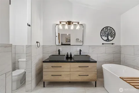 a bathroom with a granite countertop sink a toilet and bathtub