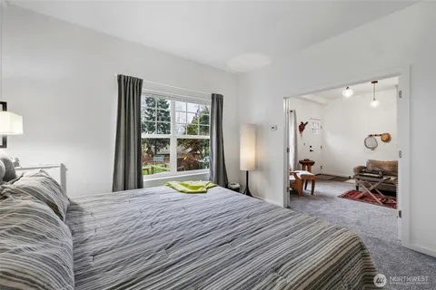 a bedroom with a bed a table and a large mirror