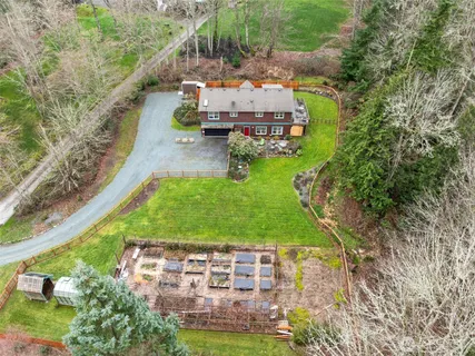an aerial view of a house with a garden and lake view