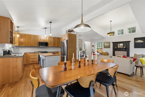 a kitchen with stainless steel appliances granite countertop a dining table and chairs