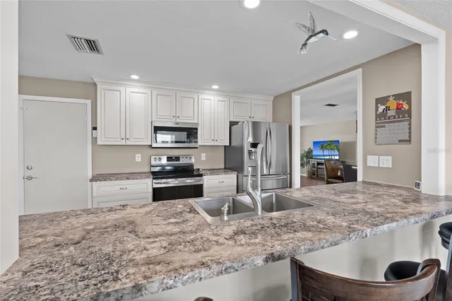 a kitchen with stainless steel appliances granite countertop a sink stove and refrigerator