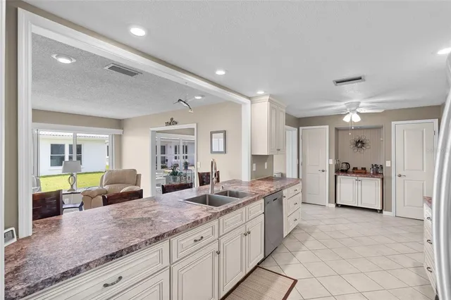 a large white kitchen with a large window and stainless steel appliances