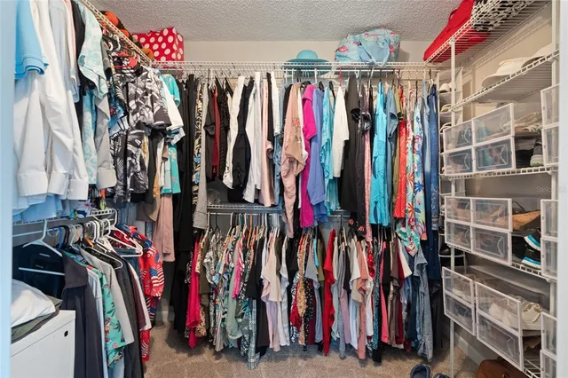 a view of walk in closet with clothes