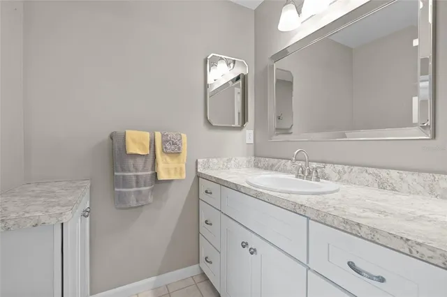 a bathroom with a granite countertop double vanity sink and mirror