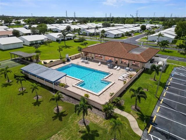 an aerial view of a chairs and table with swimming pool