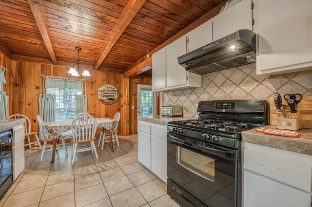 a kitchen with granite countertop a stove and a wooden floors