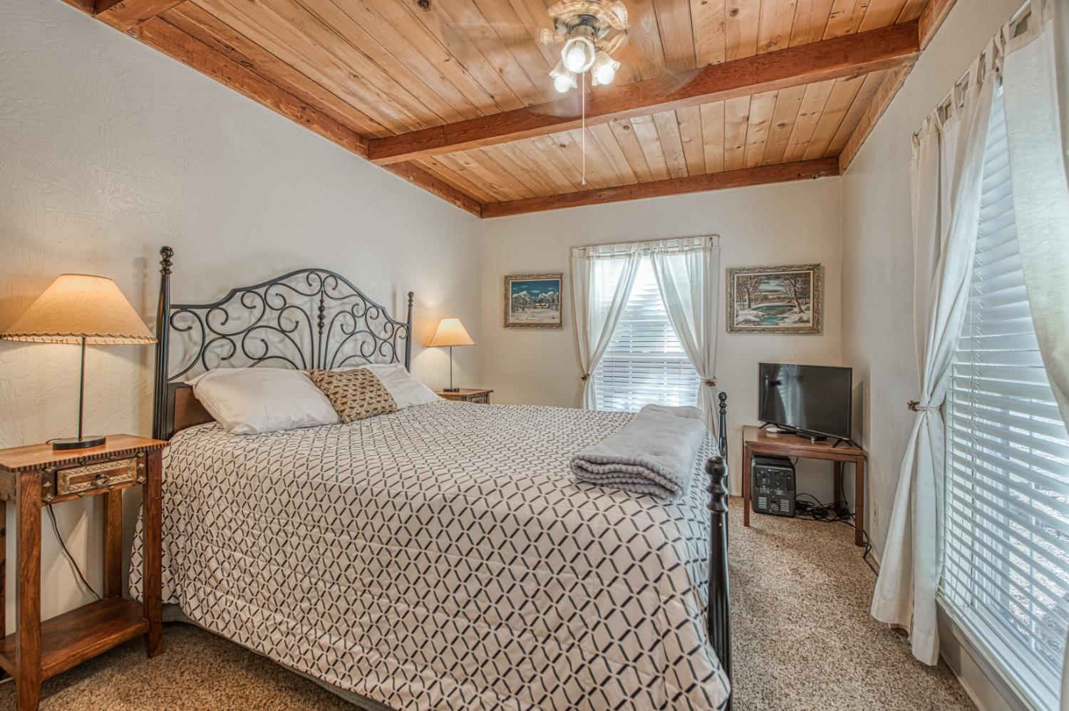 42088 North Elderberry Road Shaver Lake, CA 93664 - Photo 18 of 49 a bedroom with a large bed and a chandelier