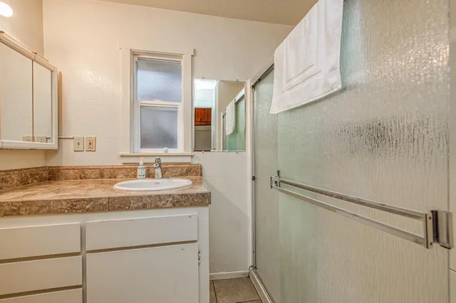 a bathroom with a granite countertop sink and a mirror