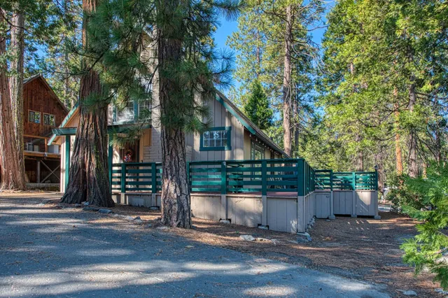 a front view of a house with a tree
