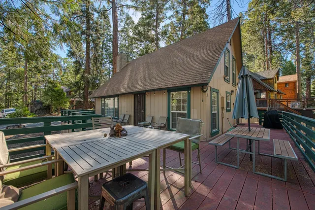 a view of a patio with table and chairs with wooden floor and fence