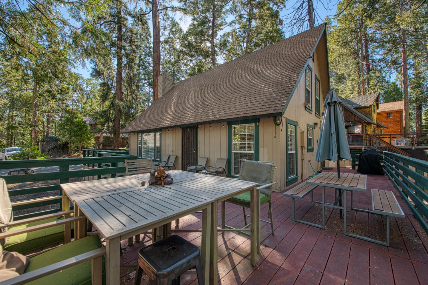 42088 North Elderberry Road Shaver Lake, CA 93664 - Photo 35 of 49 a view of a patio with table and chairs with wooden floor and fence