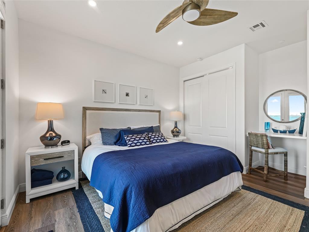 12943 Southeast Sunset Harbor Road Weirsdale, FL 32195 - Photo 63 of 87 a bedroom with a bed a dresser and wooden floor