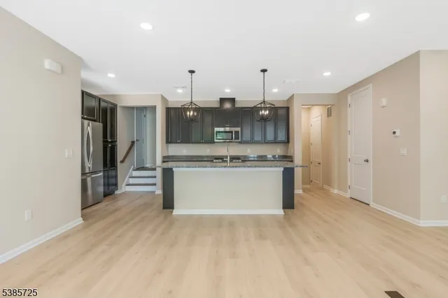 a large kitchen with a large counter top stainless steel appliances and cabinets