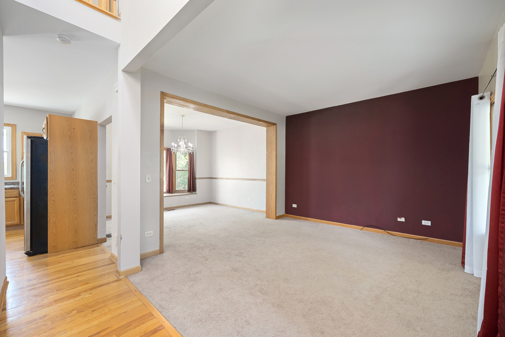 24859 Vermette Road Plainfield, IL 60585 - Photo 5 of 39 a view of an empty room with wooden floor and a kitchen