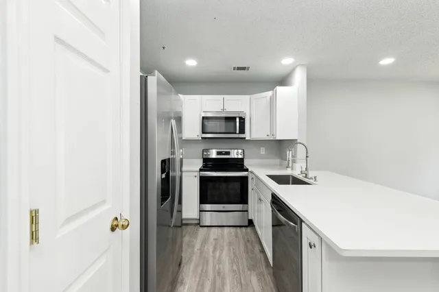 a kitchen with a sink a stove top oven and a refrigerator