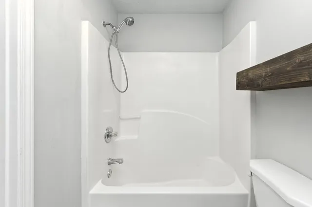 a bathroom with a bath tub with a shower
