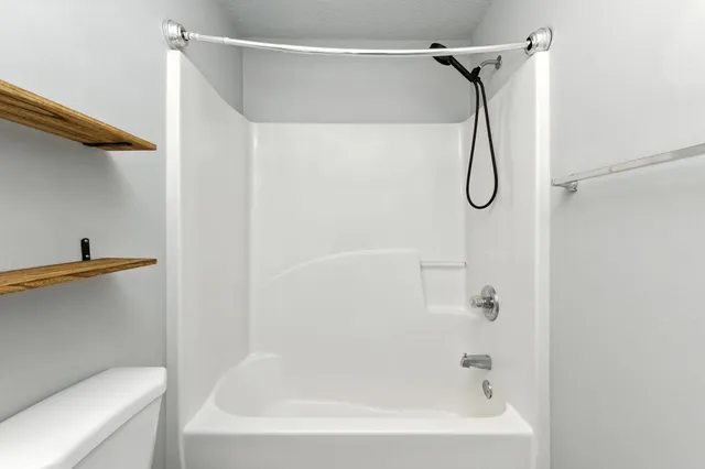 a bathroom with a bath tub with a shower