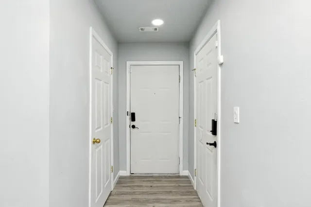 a view of a hallway with a wooden door