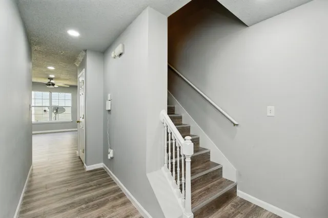a view of a hallway with wooden floor and entryway