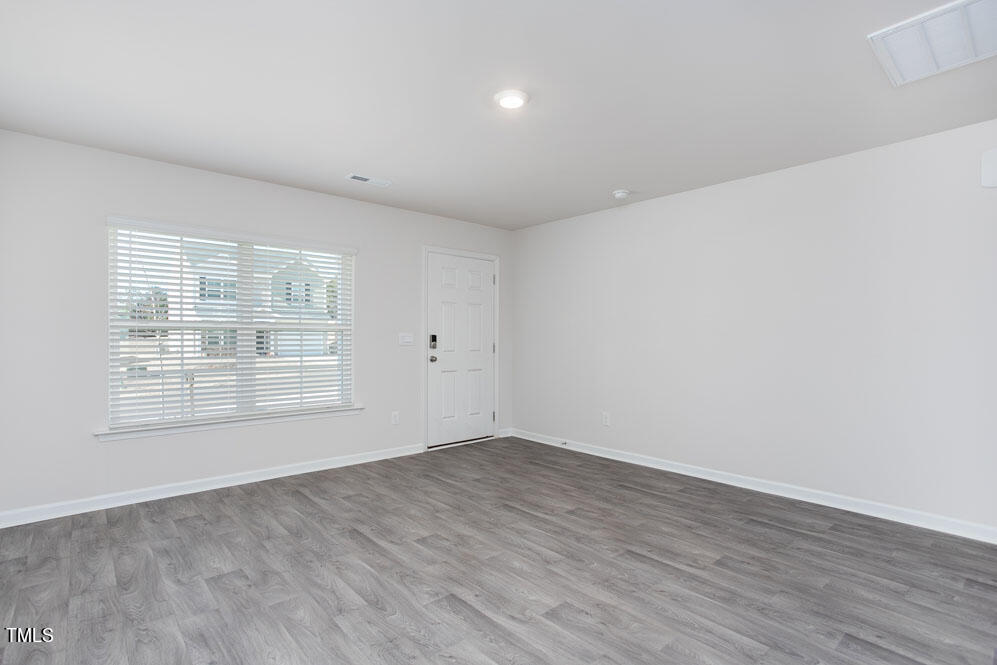 6024 Howth Way Raleigh, NC 27610 - Photo 6 of 22 an empty room with wooden floor and windows