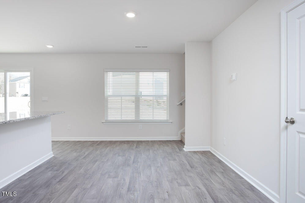 6024 Howth Way Raleigh, NC 27610 - Photo 7 of 22 an empty room with wooden floor and windows