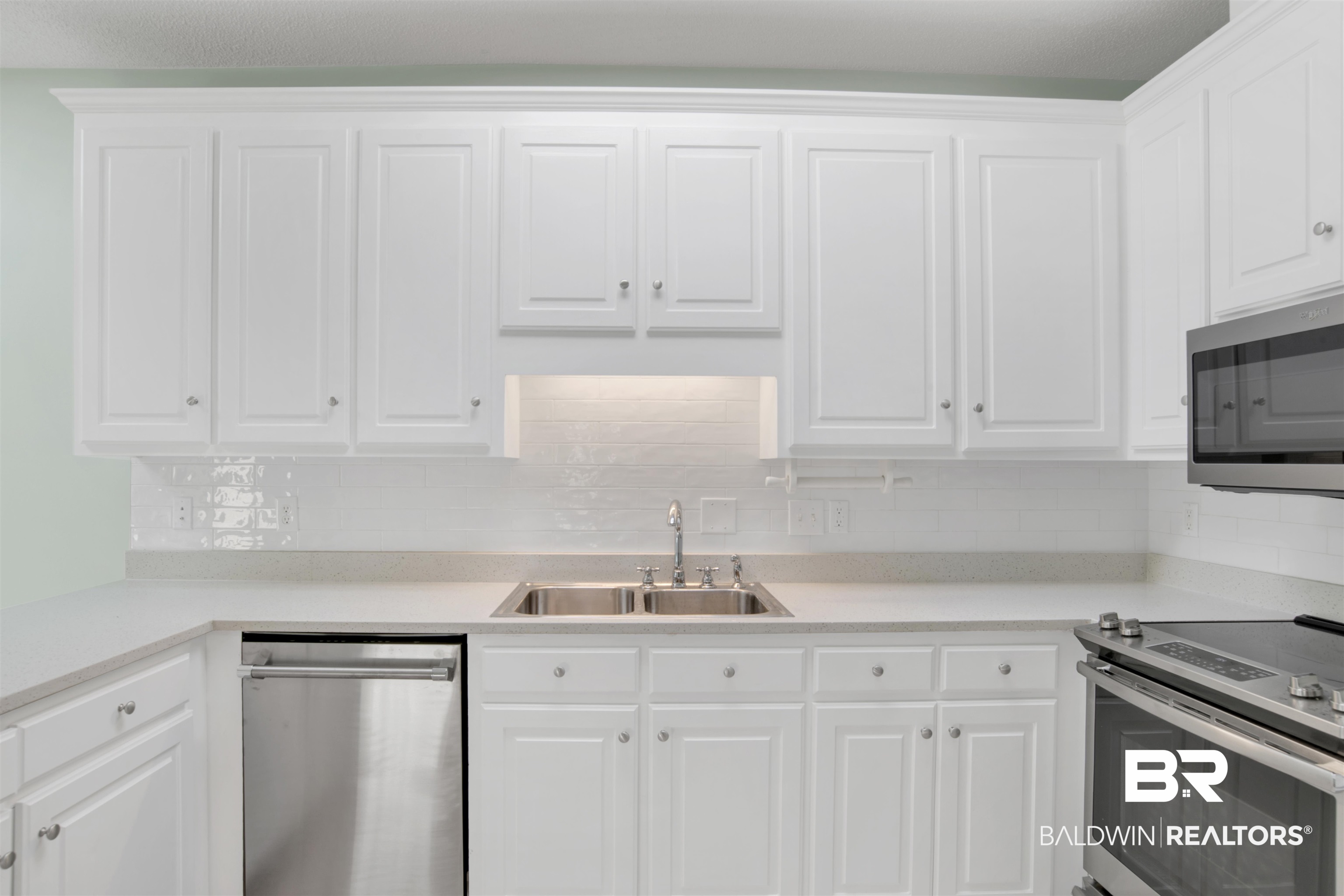 125 Woodruff Court Mobile, AL 36608 - Photo 13 of 27 Kitchen featuring white cabinetry, stainless steel appliances, tasteful backsplash, and sink