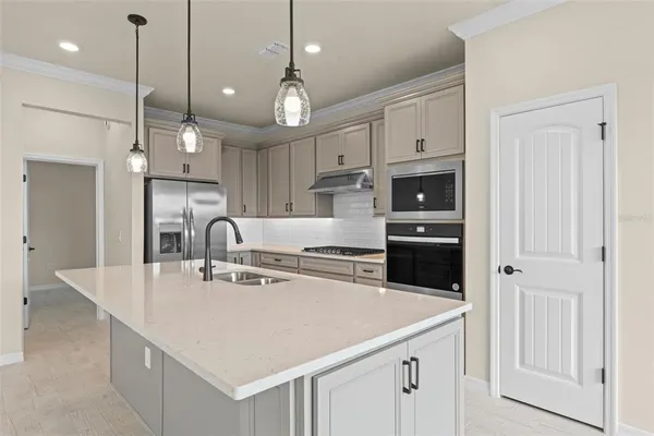 a kitchen with stainless steel appliances granite countertop a sink a refrigerator and a stove