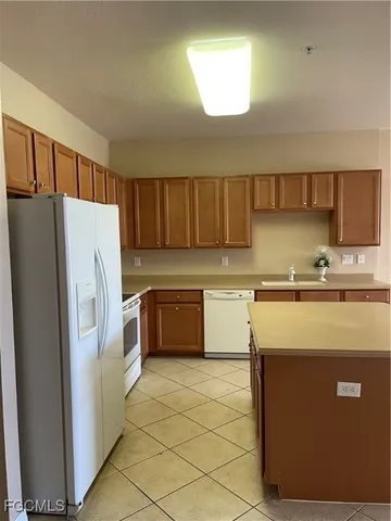 a view of kitchen with cabinets and window