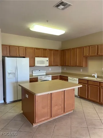 an empty room with a chandelier fan and windows