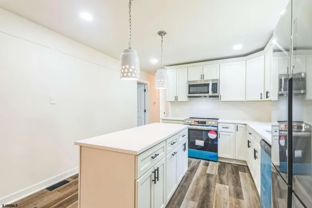 a kitchen with stainless steel appliances a stove a sink and a refrigerator