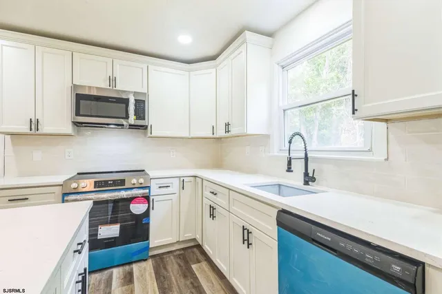 a kitchen with stainless steel appliances granite countertop a sink a stove and a microwave