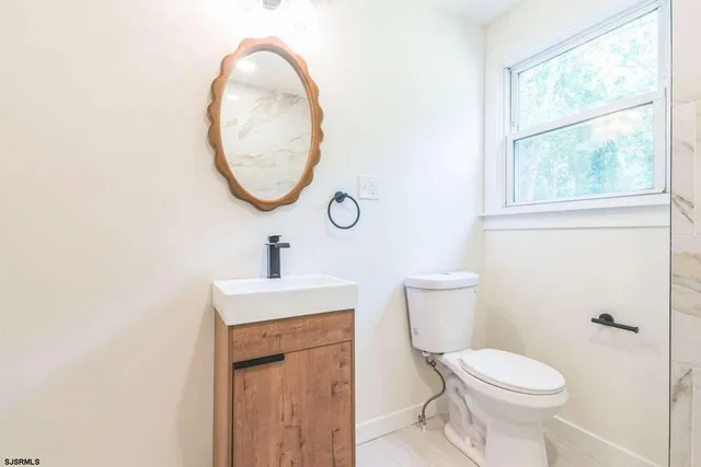 a bathroom with a toilet a sink and a mirror
