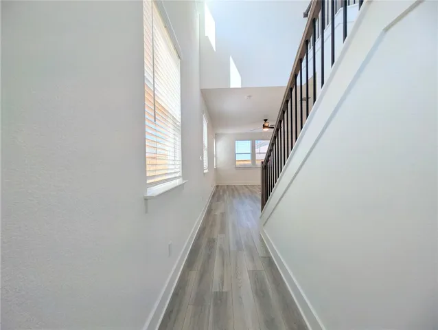 a view of a hallway with wooden floor and staircase