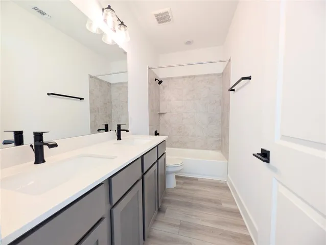 a bathroom with a sink a mirror a vanity and shower