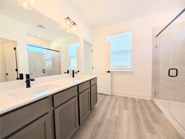 a spacious bathroom with a double vanity sink mirror and shower