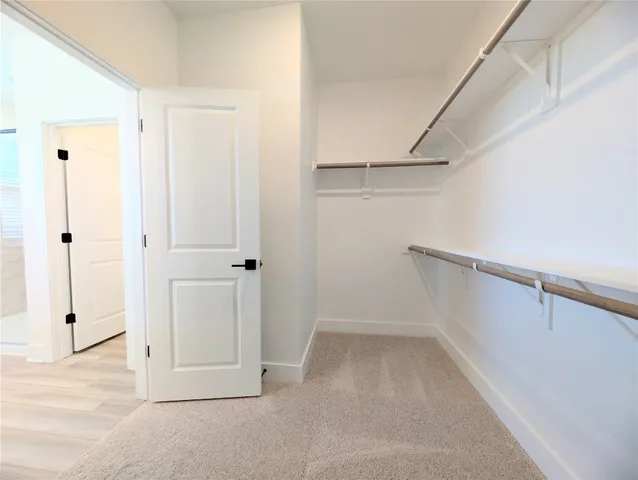 a view of walk in closet with white walls