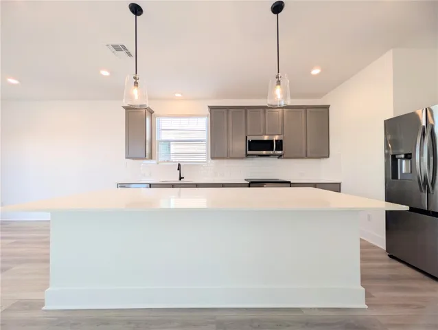 a large kitchen with stainless steel appliances kitchen island a large island in the center