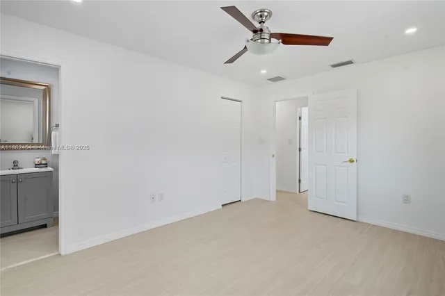 an empty room with a window and a fan