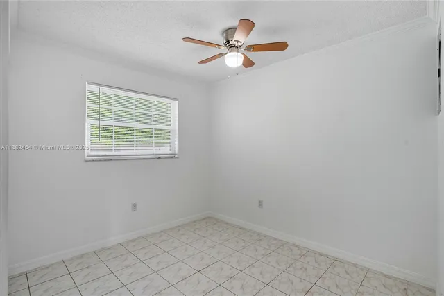 an empty room with closet and a ceiling fan