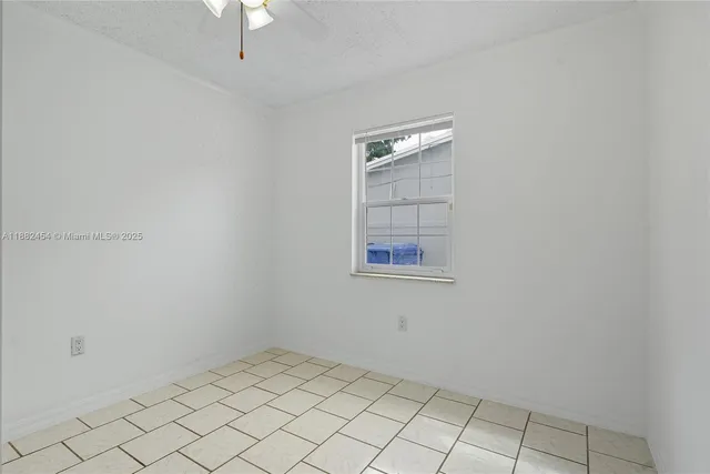 a view of an empty room and chandelier fan