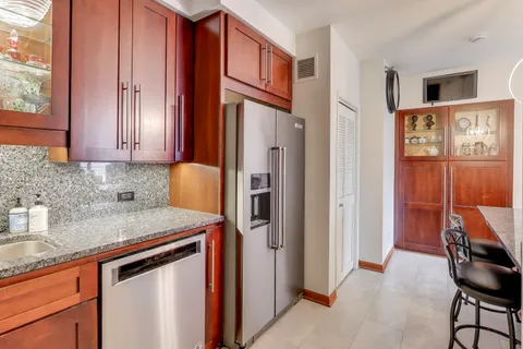 a kitchen with stainless steel appliances granite countertop a refrigerator and a sink