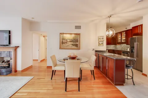 a dining room with wooden floor and stainless steel appliances