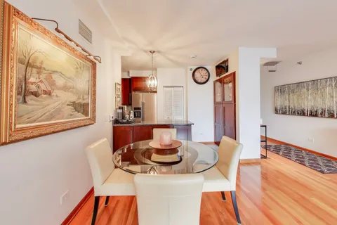 a view of a dining room with furniture a chandelier and wooden floor