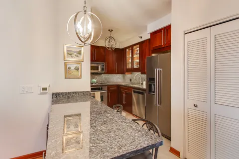 a kitchen with stainless steel appliances granite countertop a stove a sink and a refrigerator