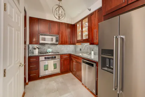 a kitchen with stainless steel appliances granite countertop a refrigerator stove a sink and dishwasher