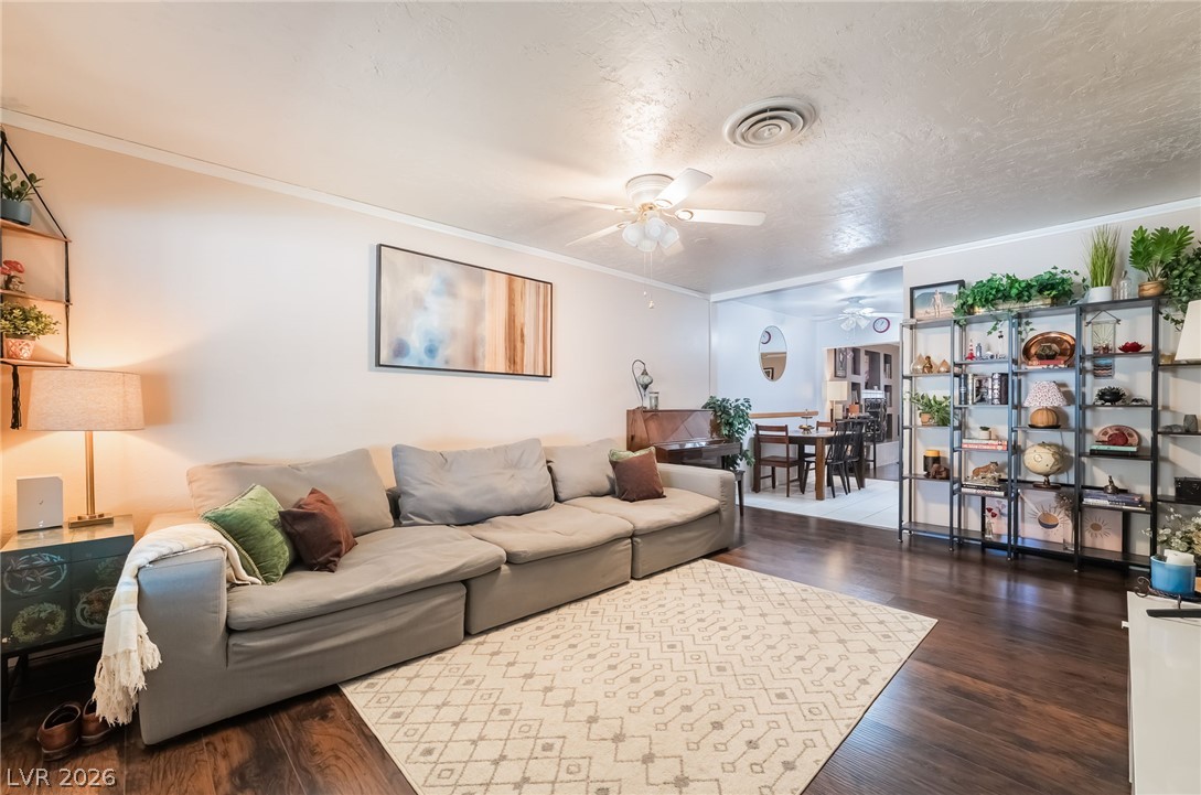 Warm wood flooring and an open layout connect the living area to the adjacent dining room.