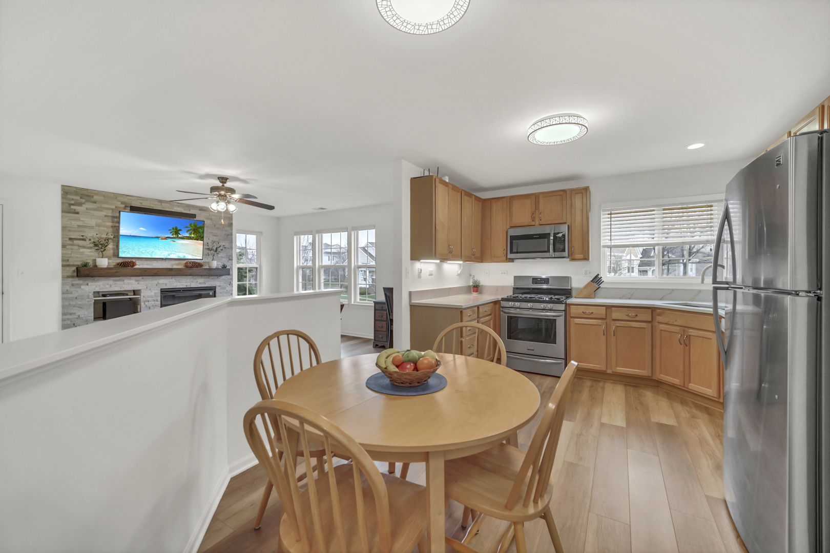 1204 Georgetown Way Vernon Hills, IL 60061 - Photo 20 of 30 a kitchen with stainless steel appliances a dining table chairs a refrigerator and microwave