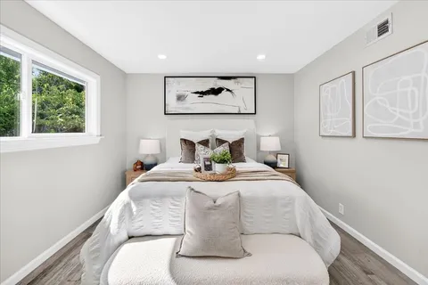 a bedroom with a bed and a painting on the wall
